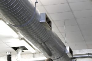 A big size metal tube for the air-conditioning installed in a workshop