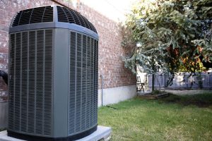 Large, black air conditioning unit in backyard